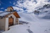 La Chapelle Sainte-Anne en hiver, sous la neige et un ciel bleu Queyras